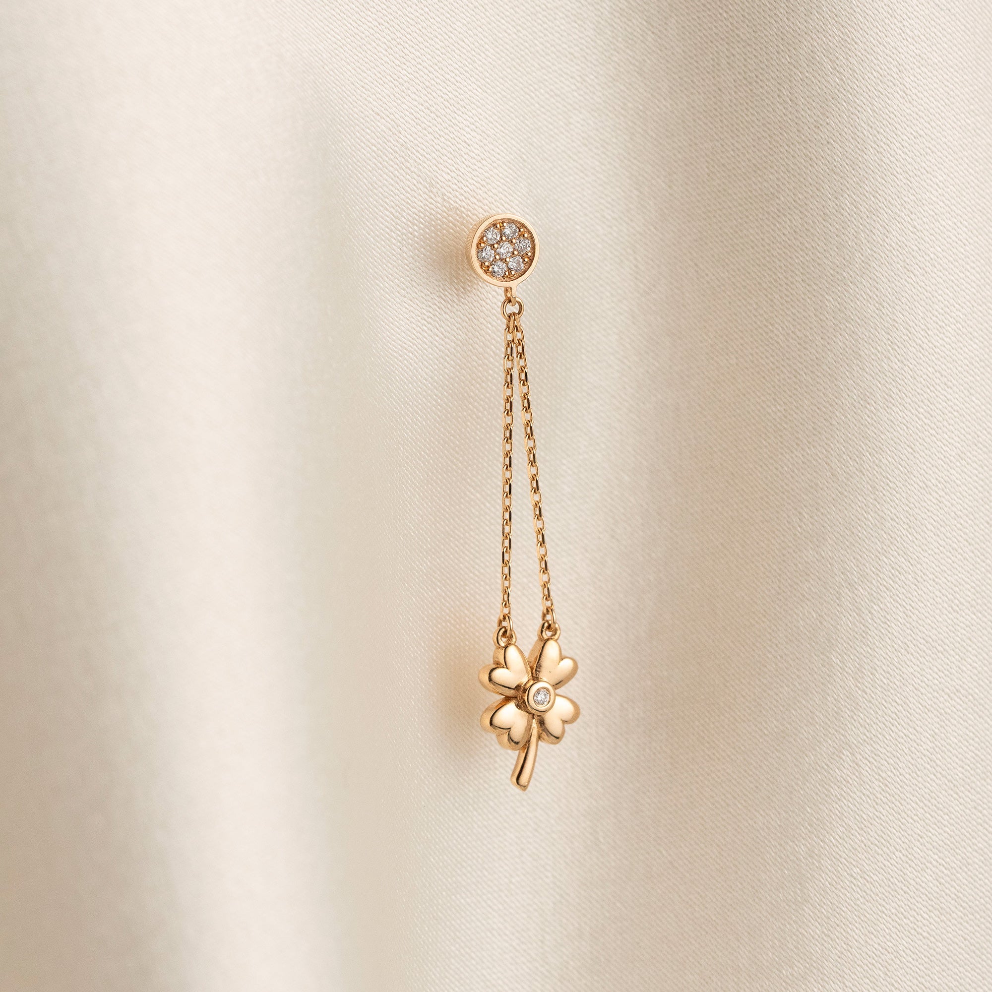 Arel Custom Jewelry 14k solid gold dangle earring with a pave diamond stud and double chain clover drop on a model.