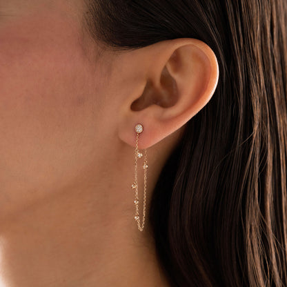 14k solid gold chain bezel earring featuring a round diamond stud and 5 diamond drops on a model.