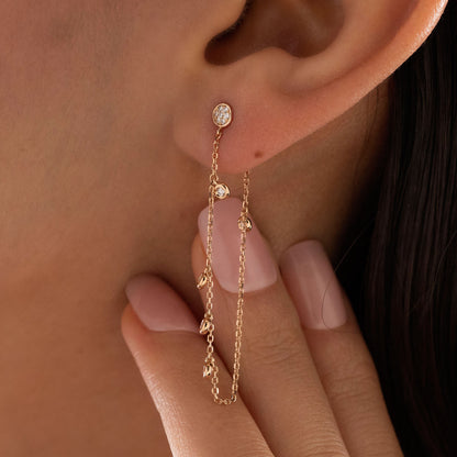 14k solid gold chain bezel earring featuring a round diamond stud and 5 diamond drops on a model.