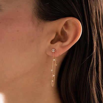 Arel Custom Jewelry 14k solid gold drape chain earring featuring a pave diamond evil eye stud and bezel diamonds on a model.
