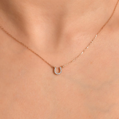 Arel Custom Jewelry 14k solid gold dainty necklace featuring a stationary pave diamond horseshoe pendant on a model.