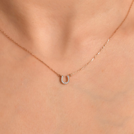 Arel Custom Jewelry 14k solid gold dainty necklace featuring a stationary pave diamond horseshoe pendant on a model.