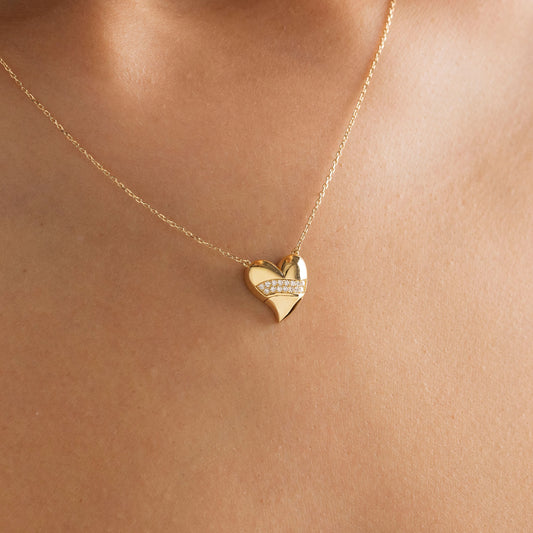 Arel Custom Jewelry 14k solid gold stationary necklace featuring a 3D domed heart pendant with a horizontal pave diamond band on a model.