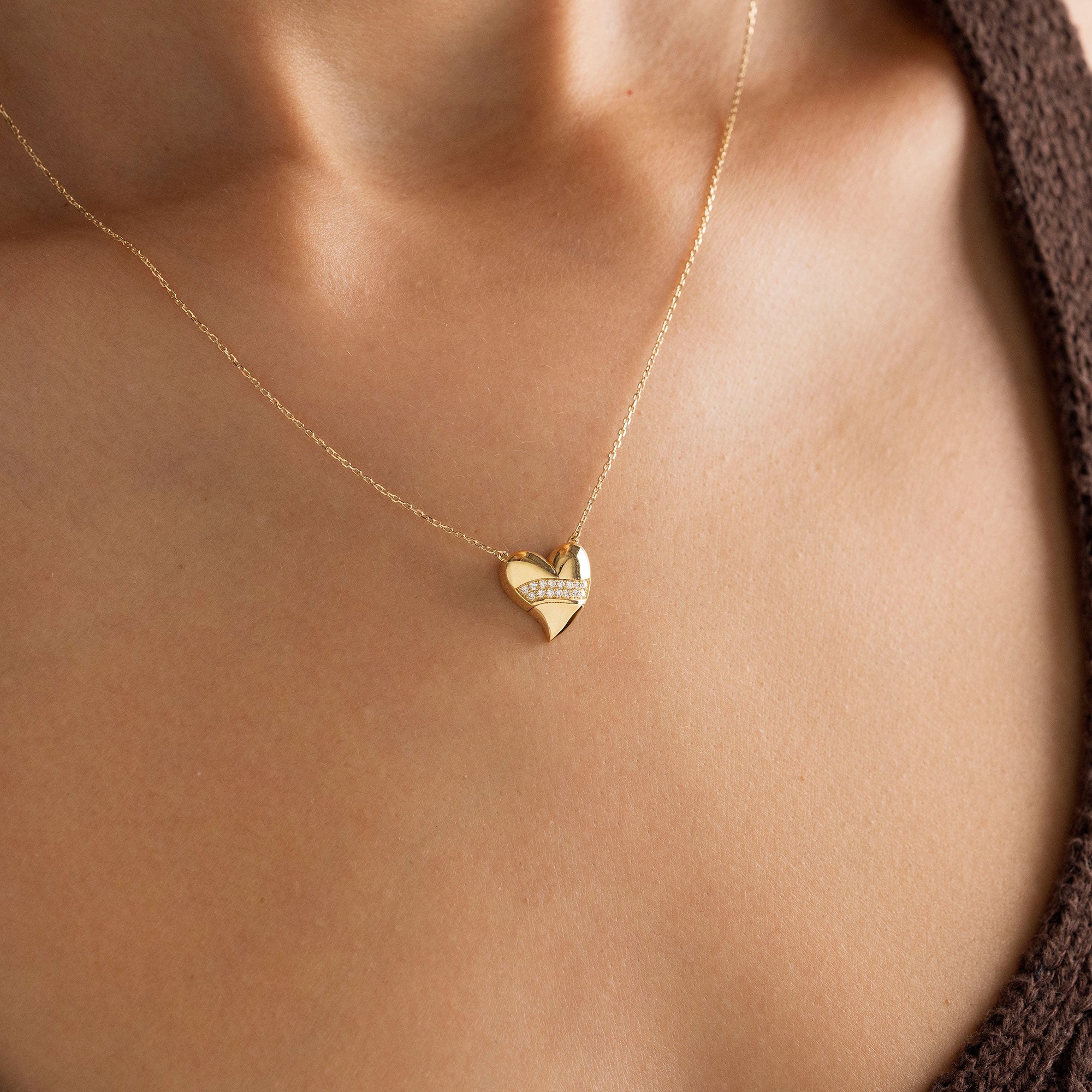 Arel Custom Jewelry 14k solid gold stationary necklace featuring a 3D domed heart pendant with a horizontal pave diamond band on a model.