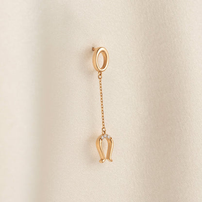 Arel Custom Jewelry 14k solid gold drop earring featuring an oval loop stud and dangling diamond horseshoe charm on a model.