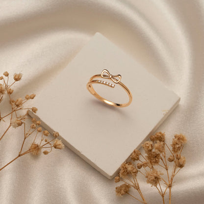 Arel Custom Jewelry 14k solid gold double band wrap ring featuring a polished bow and a pave diamond row on a model's finger.