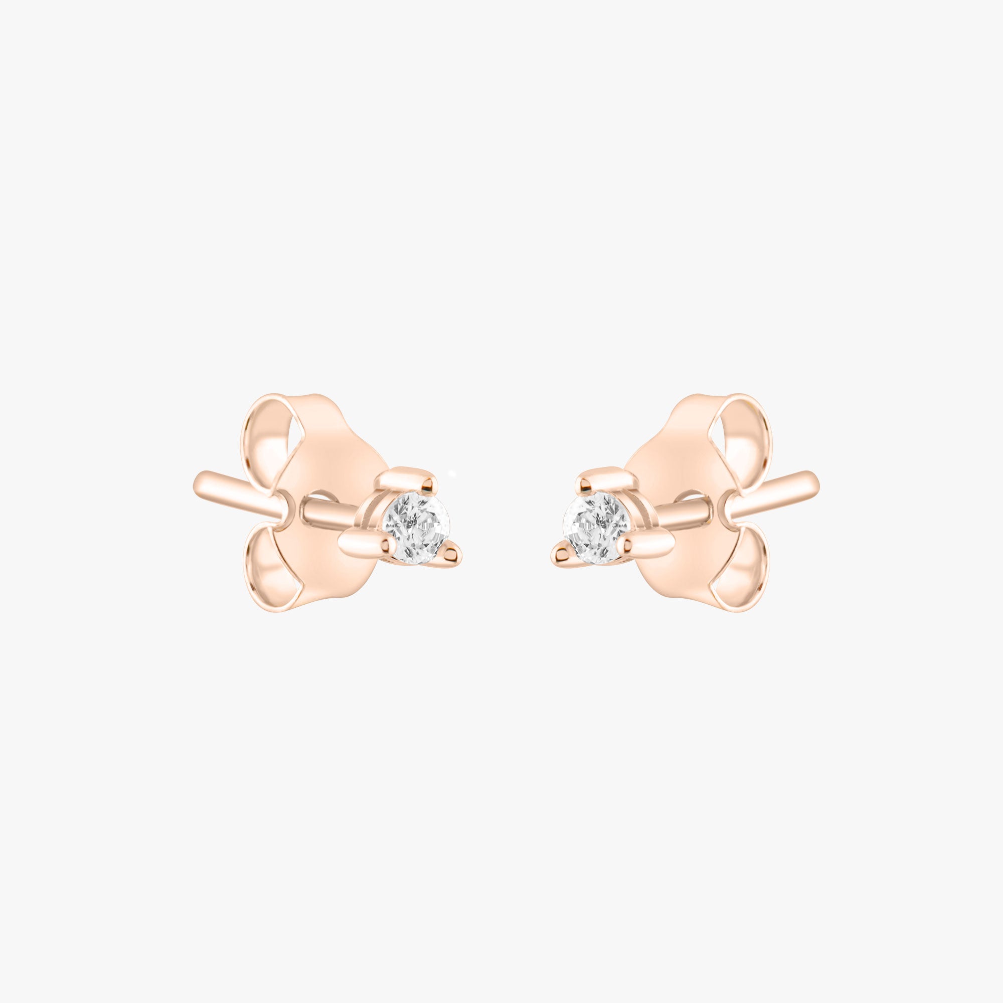 14k solid gold 3 prong diamond stud earrings featuring 2.20mm stones in rose, yellow, and white gold on a model's ear.