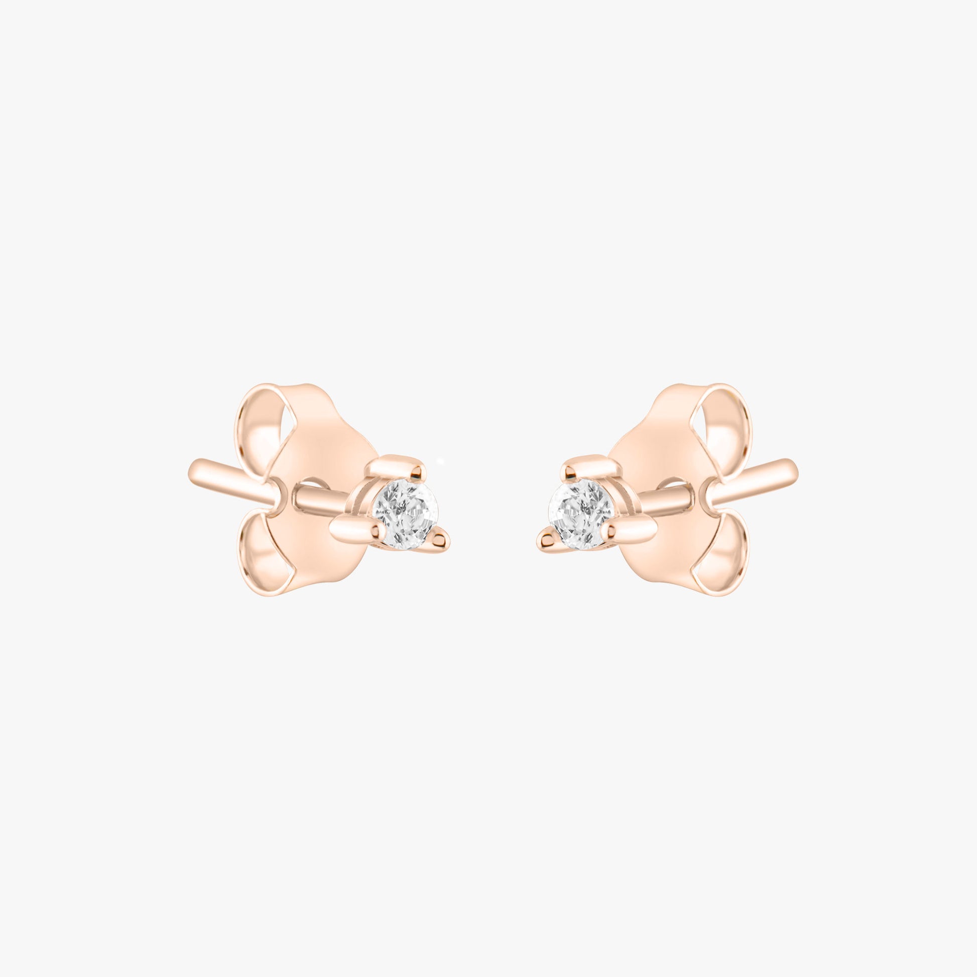 14k solid gold 3 prong diamond stud earrings featuring 2.20mm stones in rose, yellow, and white gold on a model's ear.
