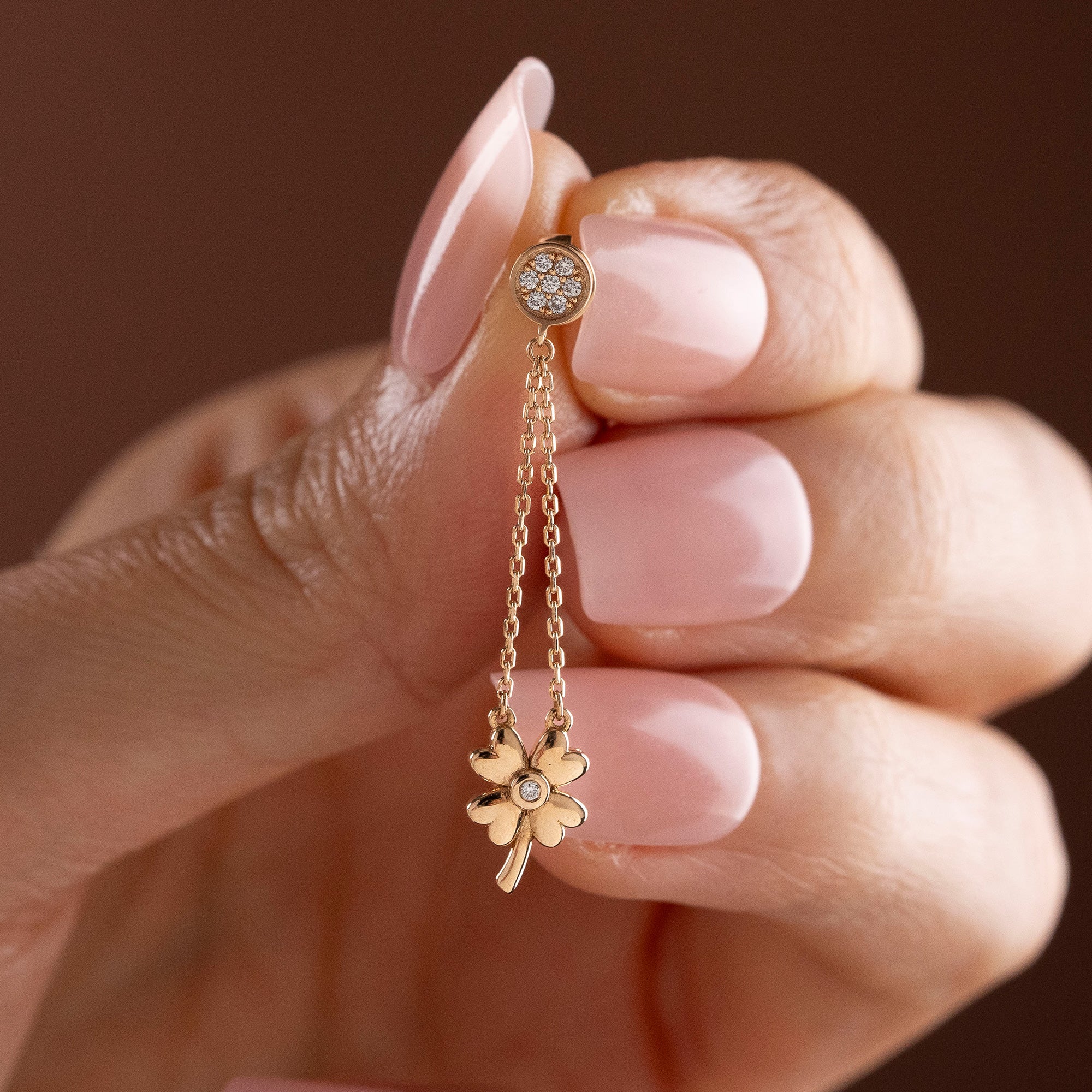 Arel Custom Jewelry 14k solid gold dangle earring with a pave diamond stud and double chain clover drop on a model.