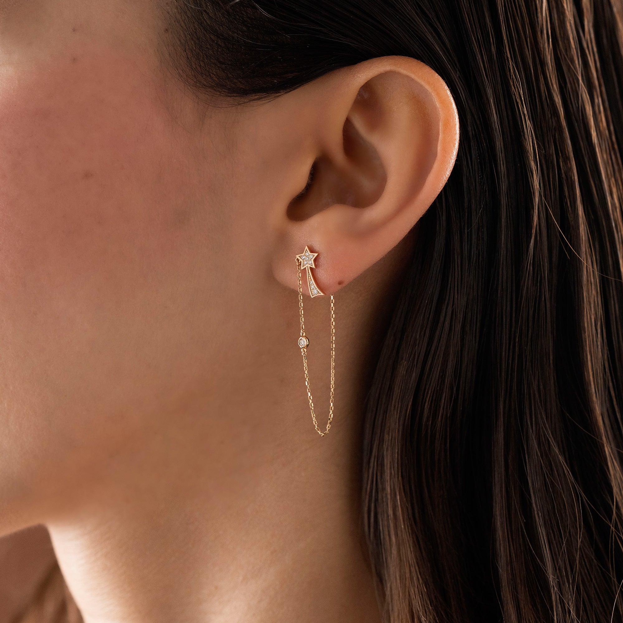 Arel Custom Jewelry 14k solid gold North Star earring with natural diamonds and a shooting star tail on model.