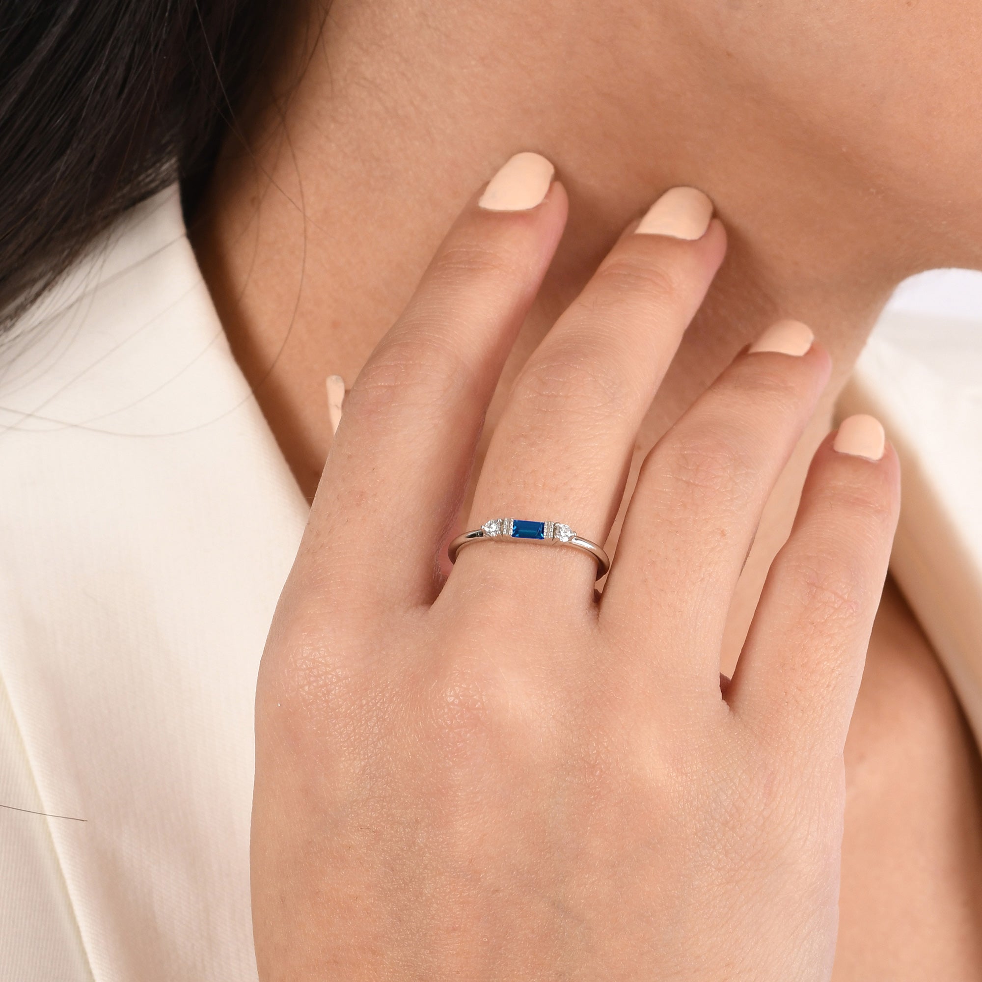 14k solid gold three stone ring featuring a 4x2mm center baguette gemstone and two 1.80mm round diamond accents on a model's hand.