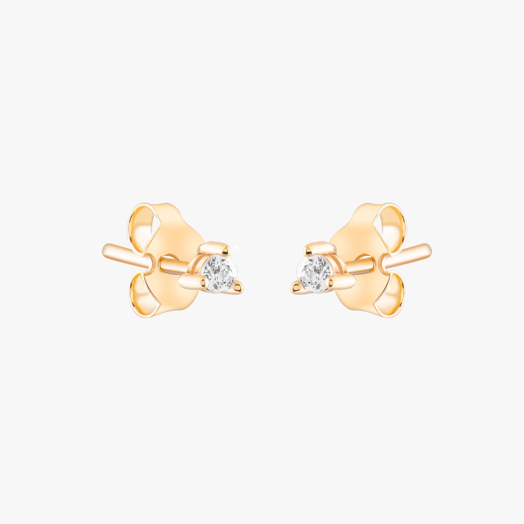 14k solid gold 3 prong diamond stud earrings featuring 2.20mm stones in rose, yellow, and white gold on a model's ear.
