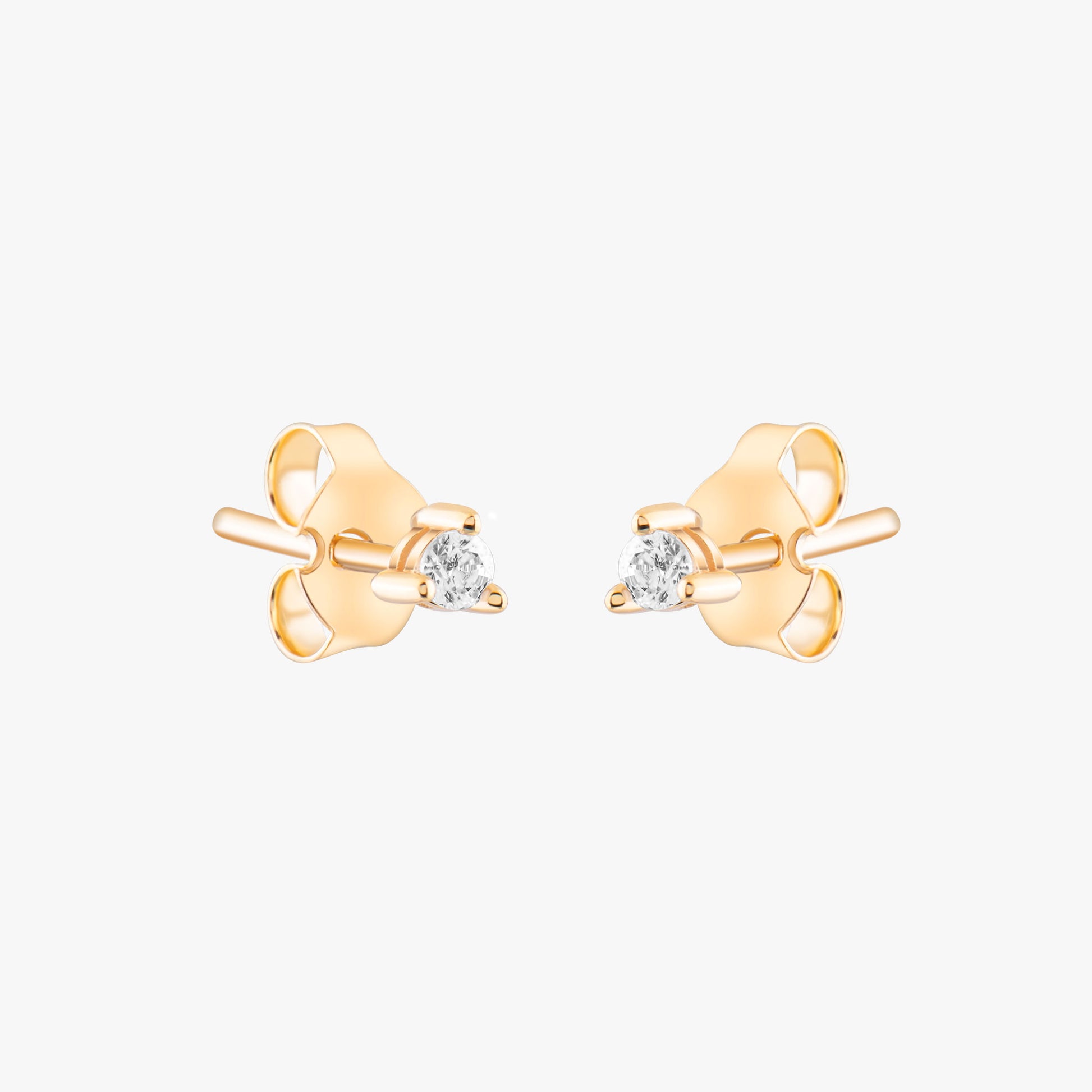 14k solid gold 3 prong diamond stud earrings featuring 2.20mm stones in rose, yellow, and white gold on a model's ear.