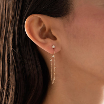 14k solid gold chain bezel earring featuring a round diamond stud and 5 diamond drops on a model.