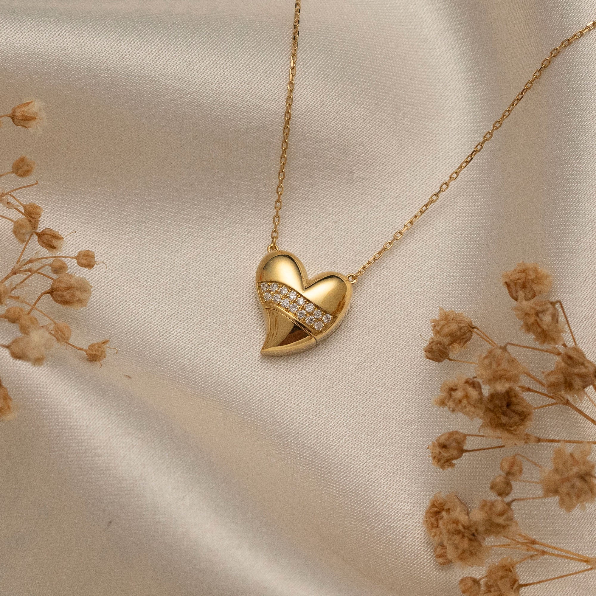 Arel Custom Jewelry 14k solid gold stationary necklace featuring a 3D domed heart pendant with a horizontal pave diamond band on a model.