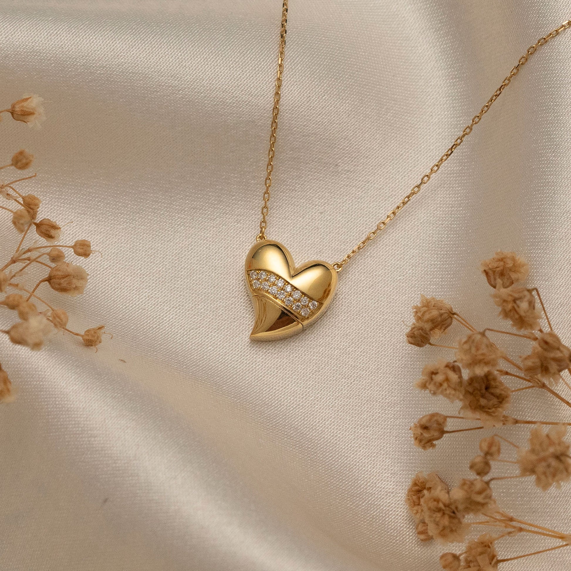 Arel Custom Jewelry 14k solid gold stationary necklace featuring a 3D domed heart pendant with a horizontal pave diamond band on a model.