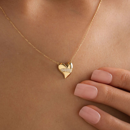 Arel Custom Jewelry 14k solid gold stationary necklace featuring a 3D domed heart pendant with a horizontal pave diamond band on a model.
