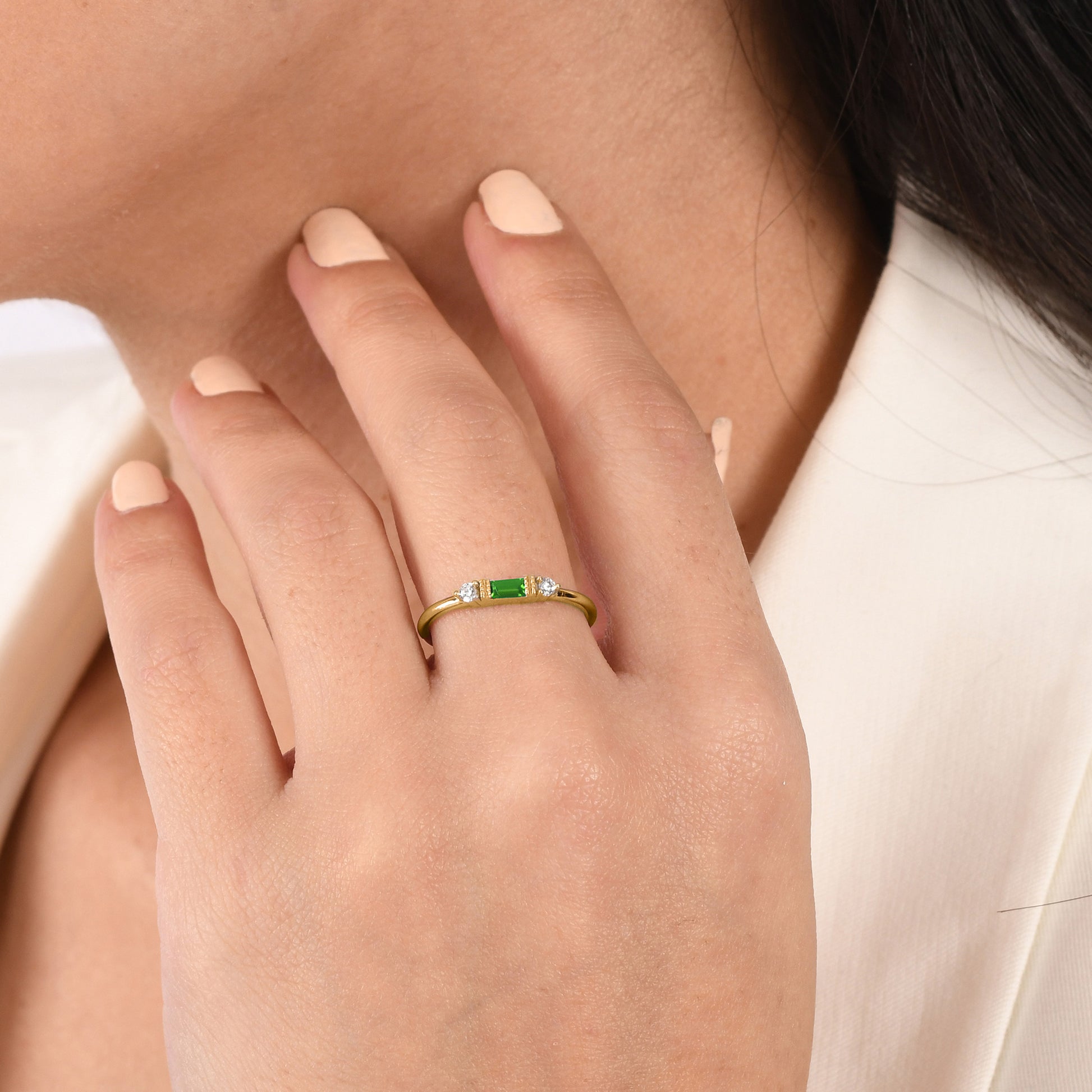 14k solid gold three stone ring featuring a 4x2mm center baguette gemstone and two 1.80mm round diamond accents on a model's hand.