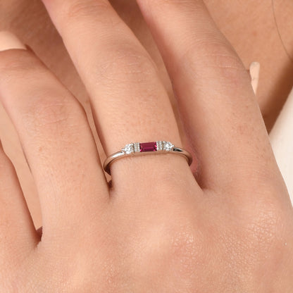 14k solid gold three stone ring featuring a 4x2mm center baguette gemstone and two 1.80mm round diamond accents on a model's hand.