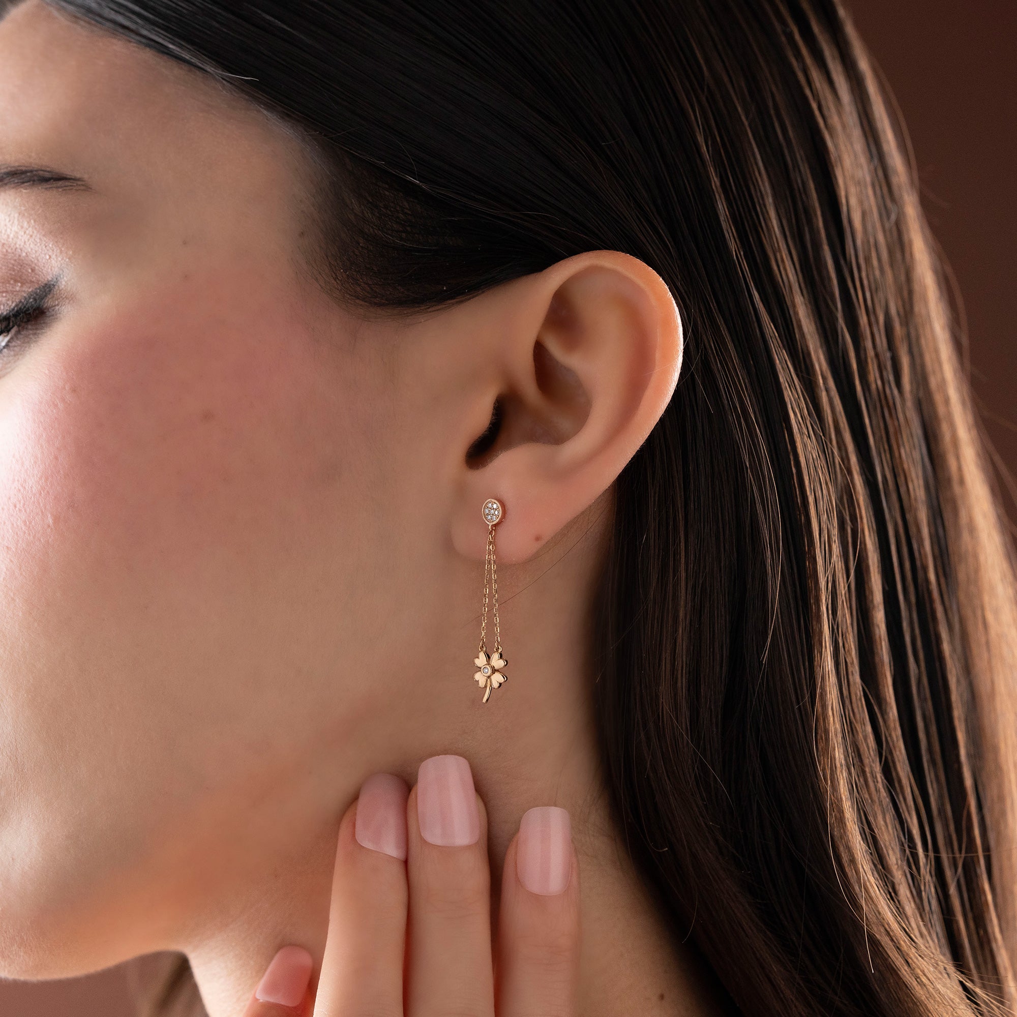 Arel Custom Jewelry 14k solid gold dangle earring with a pave diamond stud and double chain clover drop on a model.