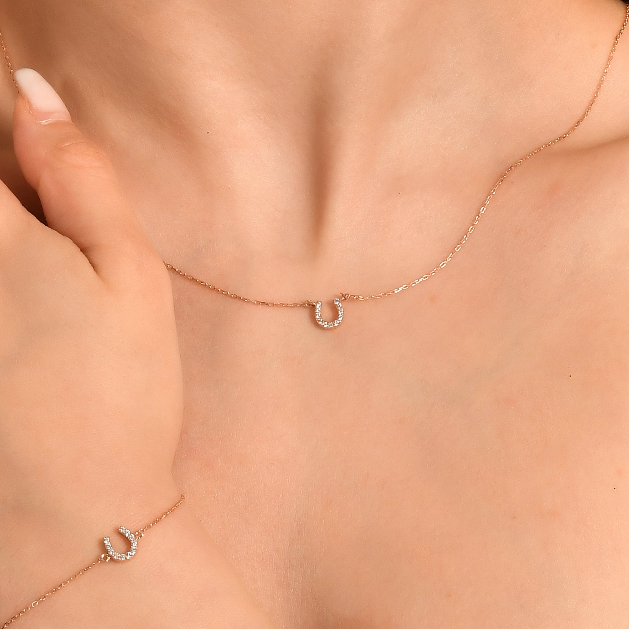 Arel Custom Jewelry 14k solid gold dainty necklace featuring a stationary pave diamond horseshoe pendant on a model.