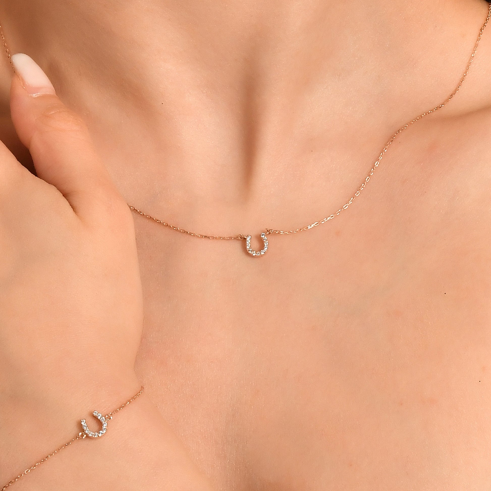 Arel Custom Jewelry 14k solid gold dainty necklace featuring a stationary pave diamond horseshoe pendant on a model.