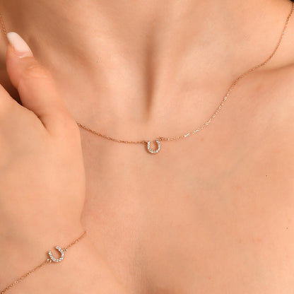 Arel Custom Jewelry 14k solid gold dainty necklace featuring a stationary pave diamond horseshoe pendant on a model.