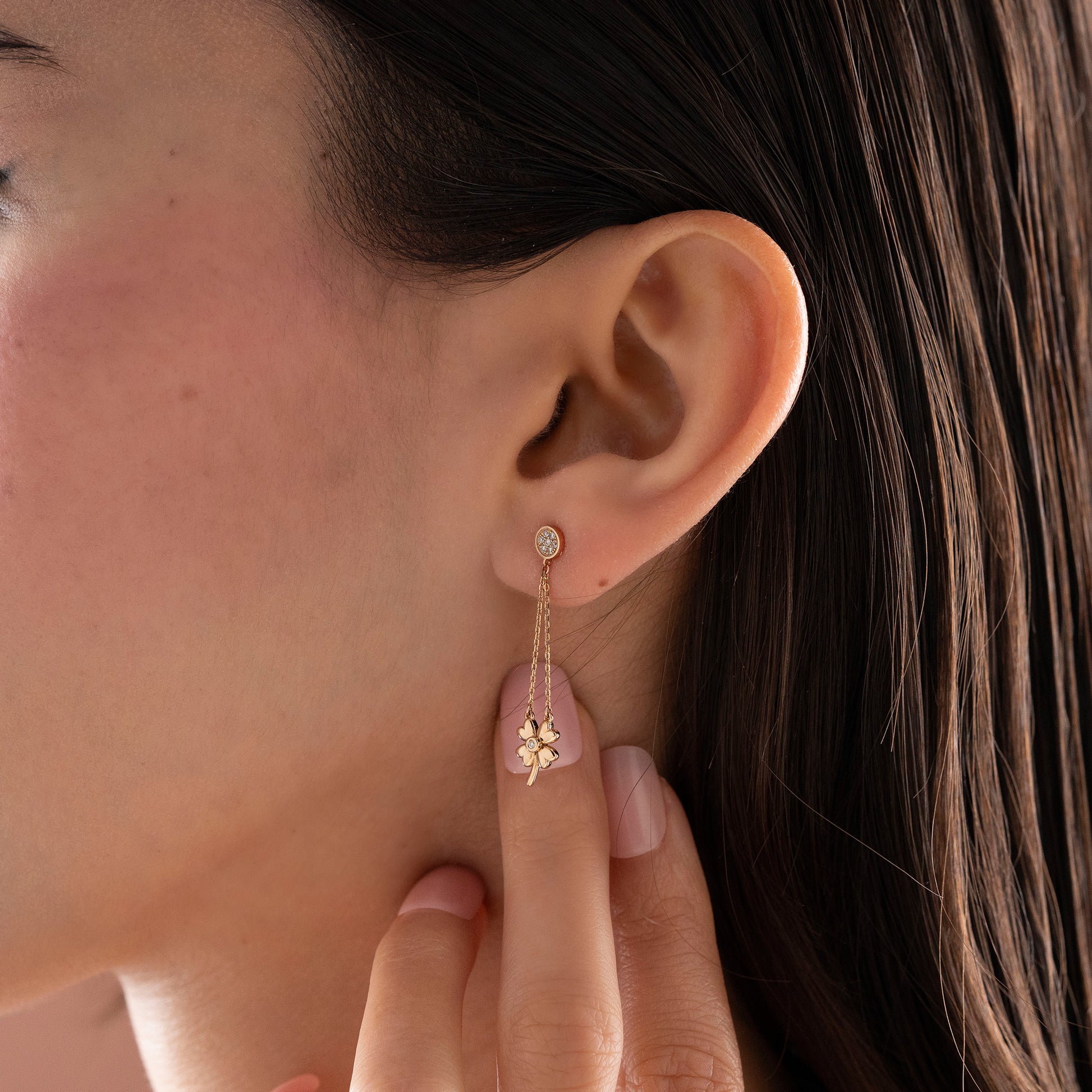 Arel Custom Jewelry 14k solid gold dangle earring with a pave diamond stud and double chain clover drop on a model.