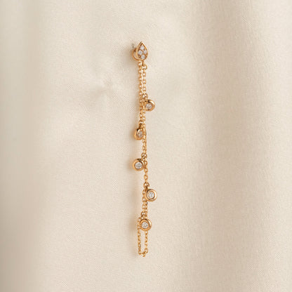 Arel Custom Jewelry 14k solid gold drape chain earring featuring a diamond teardrop stud and bezel diamonds on a model.