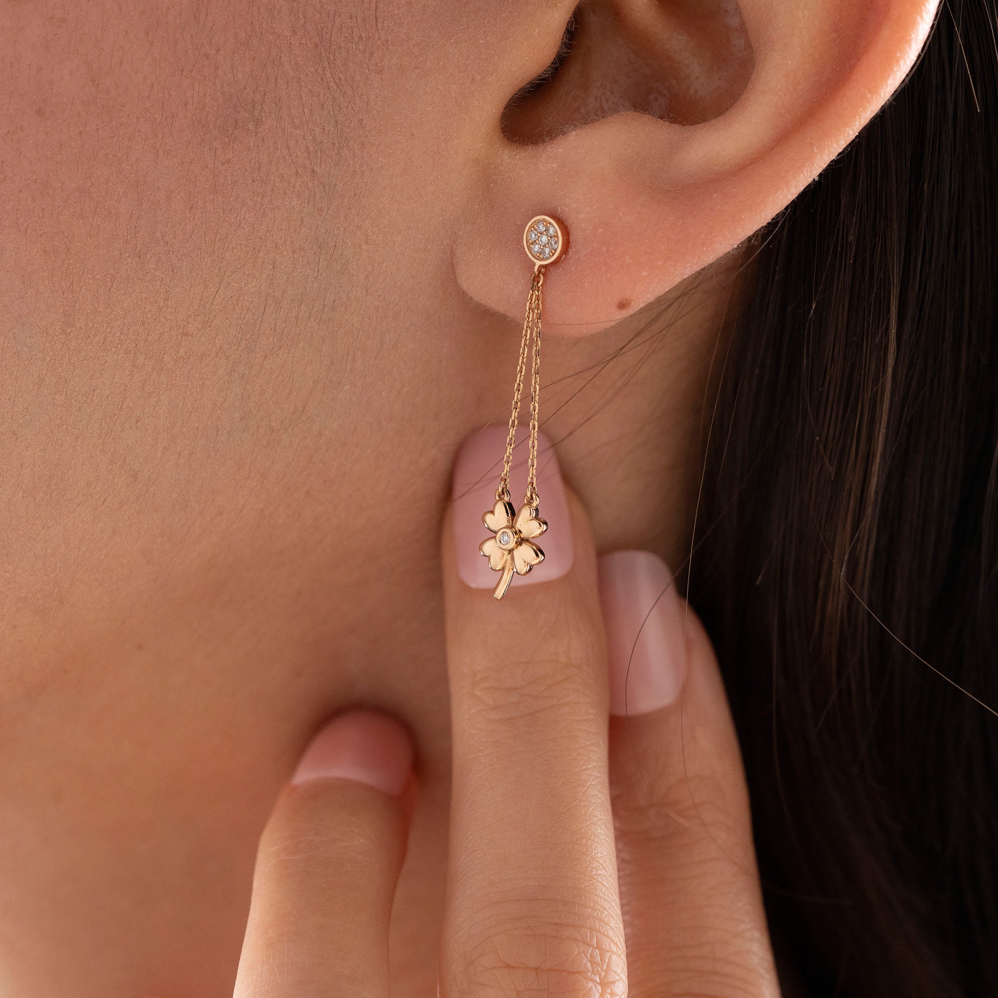 Arel Custom Jewelry 14k solid gold dangle earring with a pave diamond stud and double chain clover drop on a model.