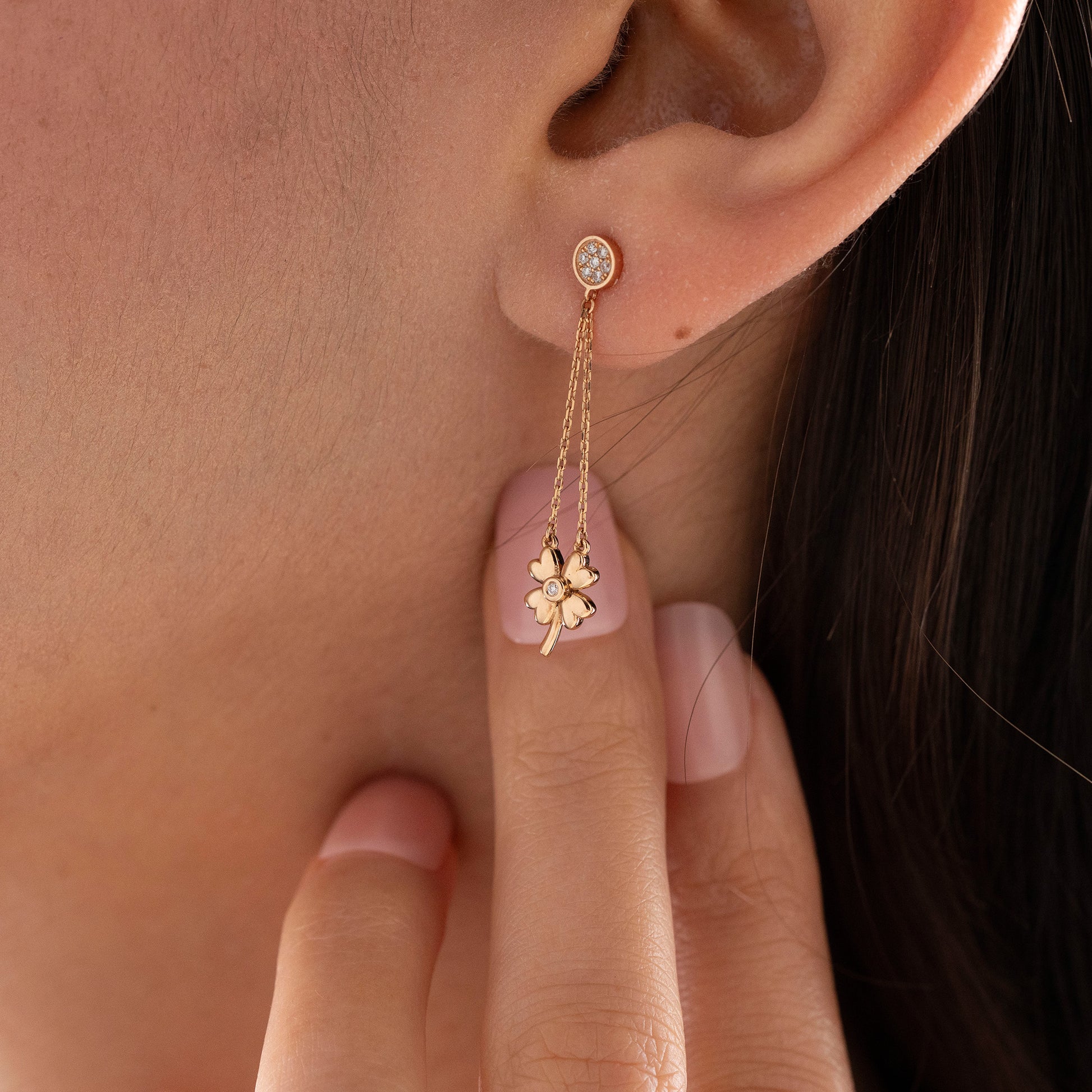 Arel Custom Jewelry 14k solid gold dangle earring with a pave diamond stud and double chain clover drop on a model.