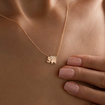 Arel Custom Jewelry 14k solid gold necklace featuring a polished elephant pendant with a pave diamond ear and trunk up on a model.