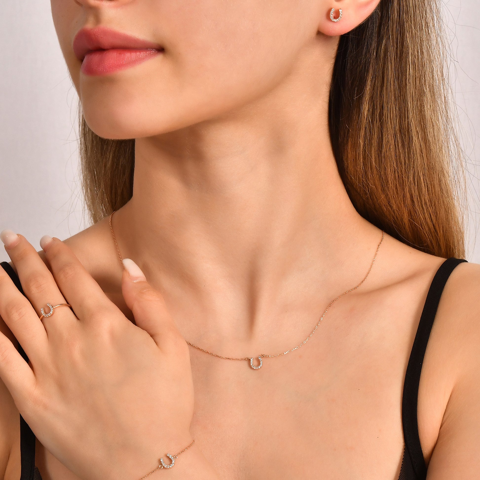 Arel Custom Jewelry 14k solid gold dainty necklace featuring a stationary pave diamond horseshoe pendant on a model.