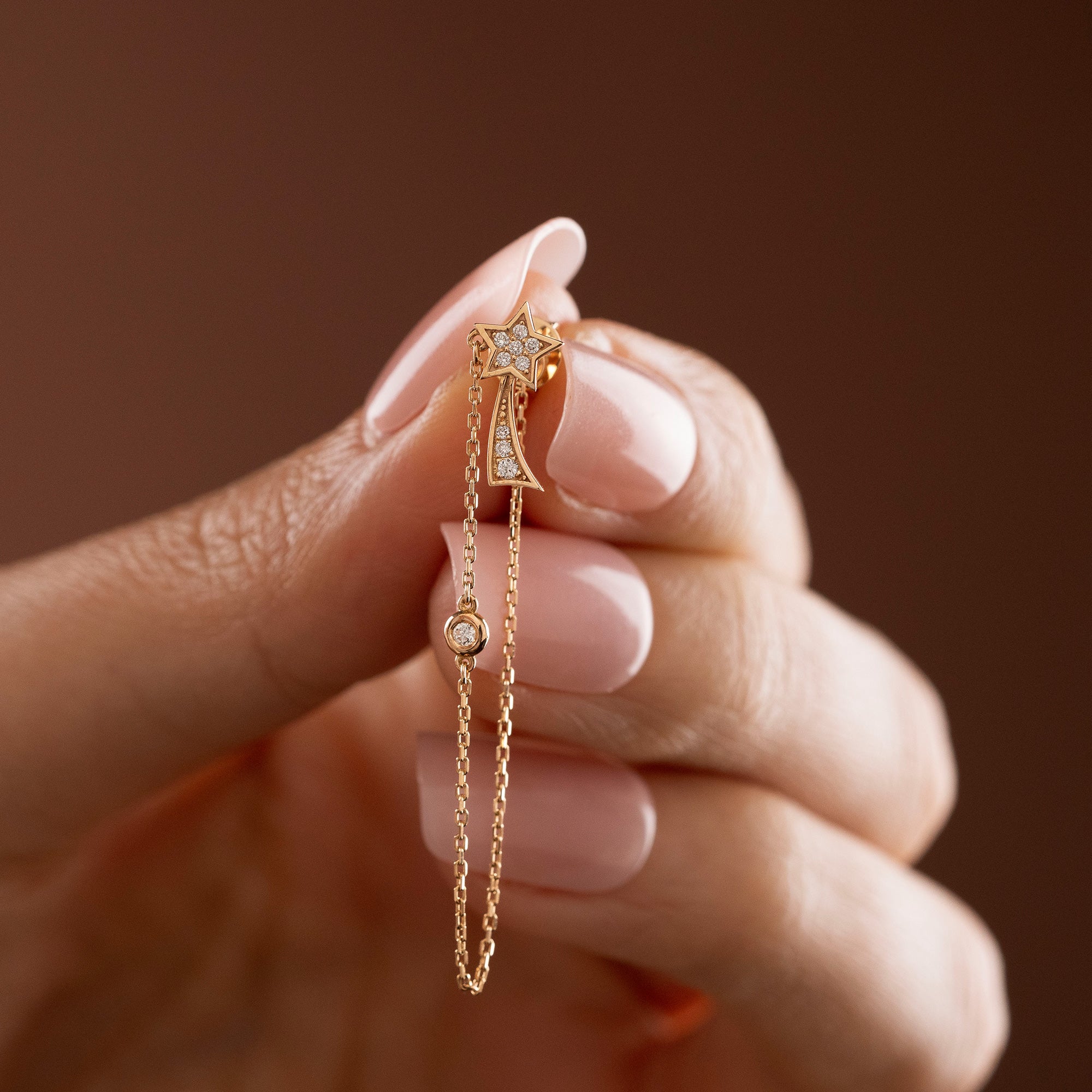 Arel Custom Jewelry 14k solid gold North Star earring with natural diamonds and a shooting star tail on model.
