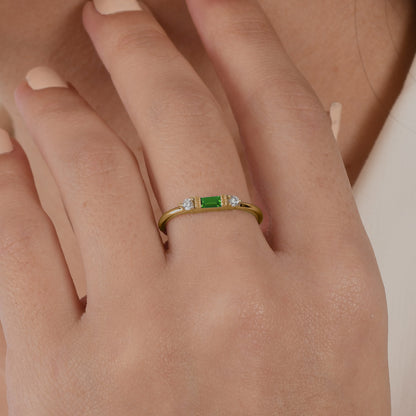 14k solid gold three stone ring featuring a 4x2mm center baguette gemstone and two 1.80mm round diamond accents on a model's hand.