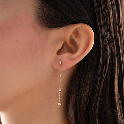 Arel Custom Jewelry 14k solid gold teardrop earring with natural diamonds on a dangling chain, worn by a model.
