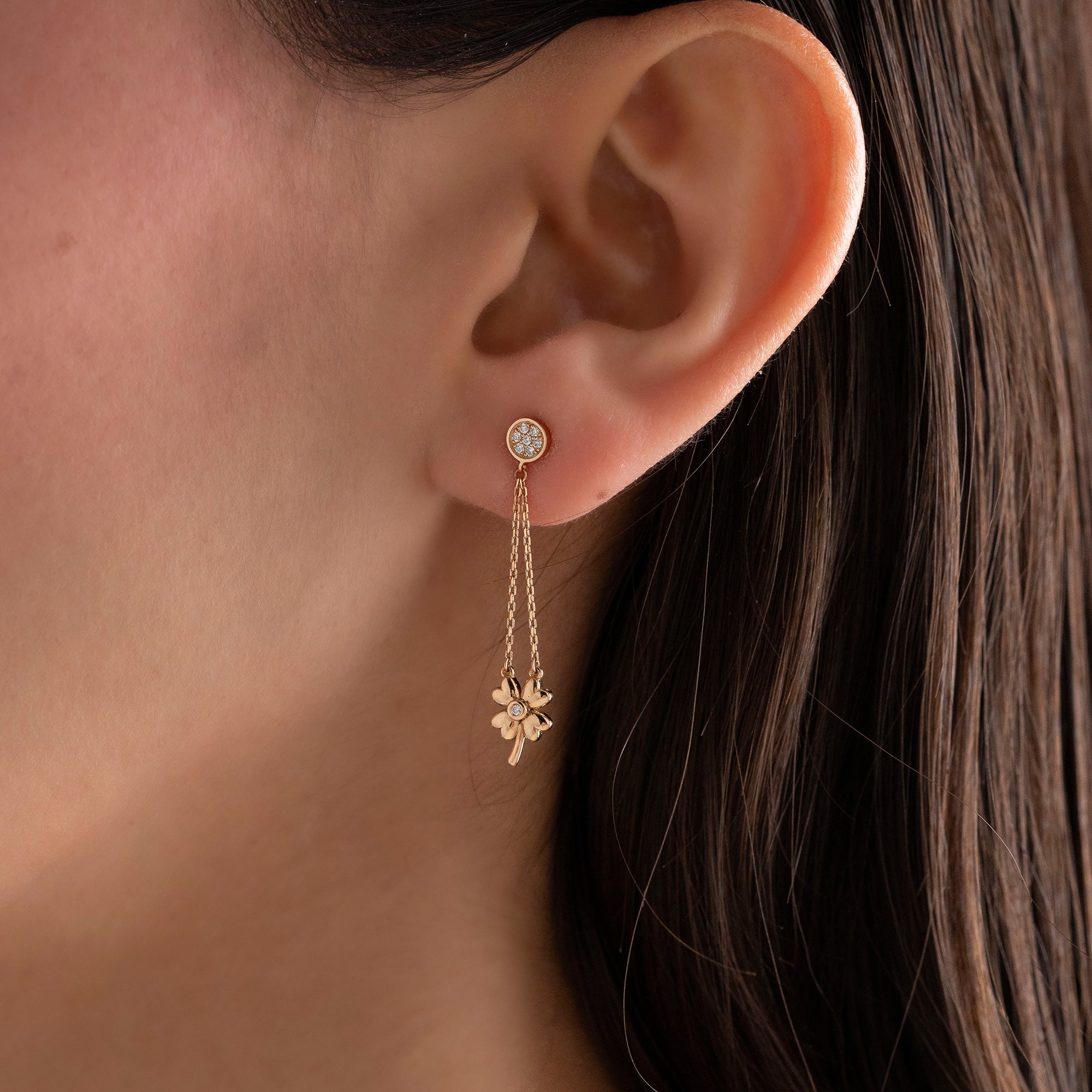 Arel Custom Jewelry 14k solid gold dangle earring with a pave diamond stud and double chain clover drop on a model.