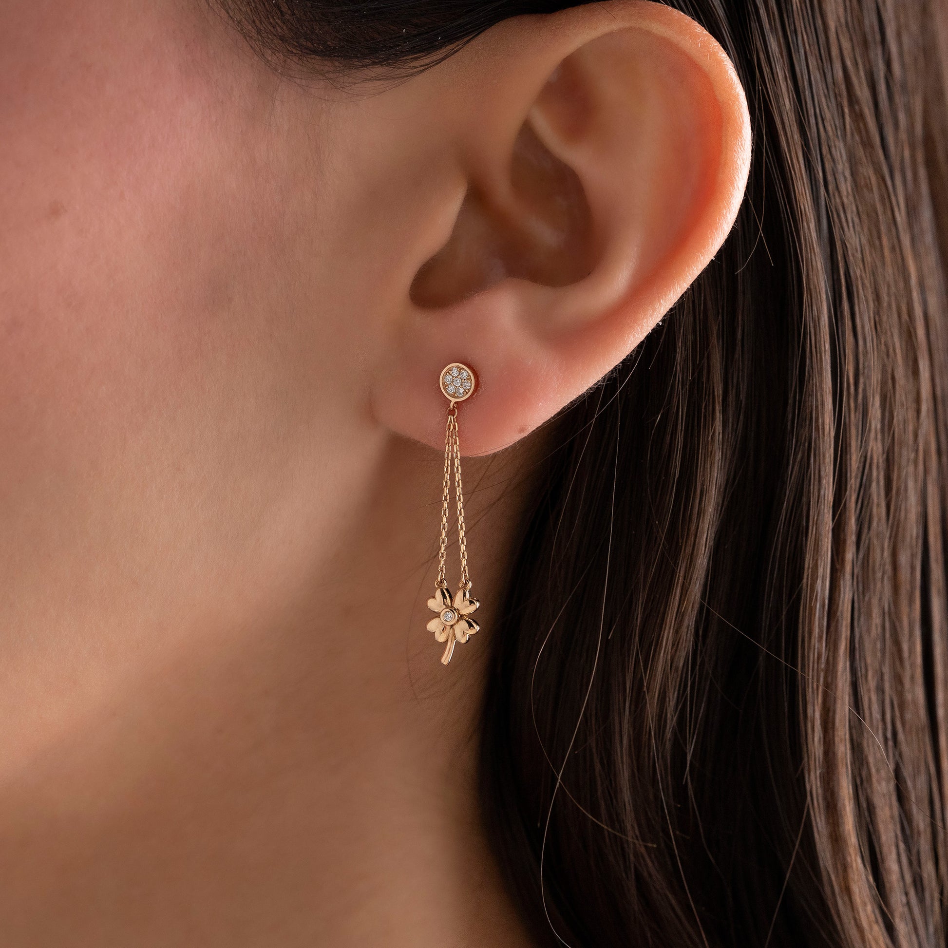 Arel Custom Jewelry 14k solid gold dangle earring with a pave diamond stud and double chain clover drop on a model.