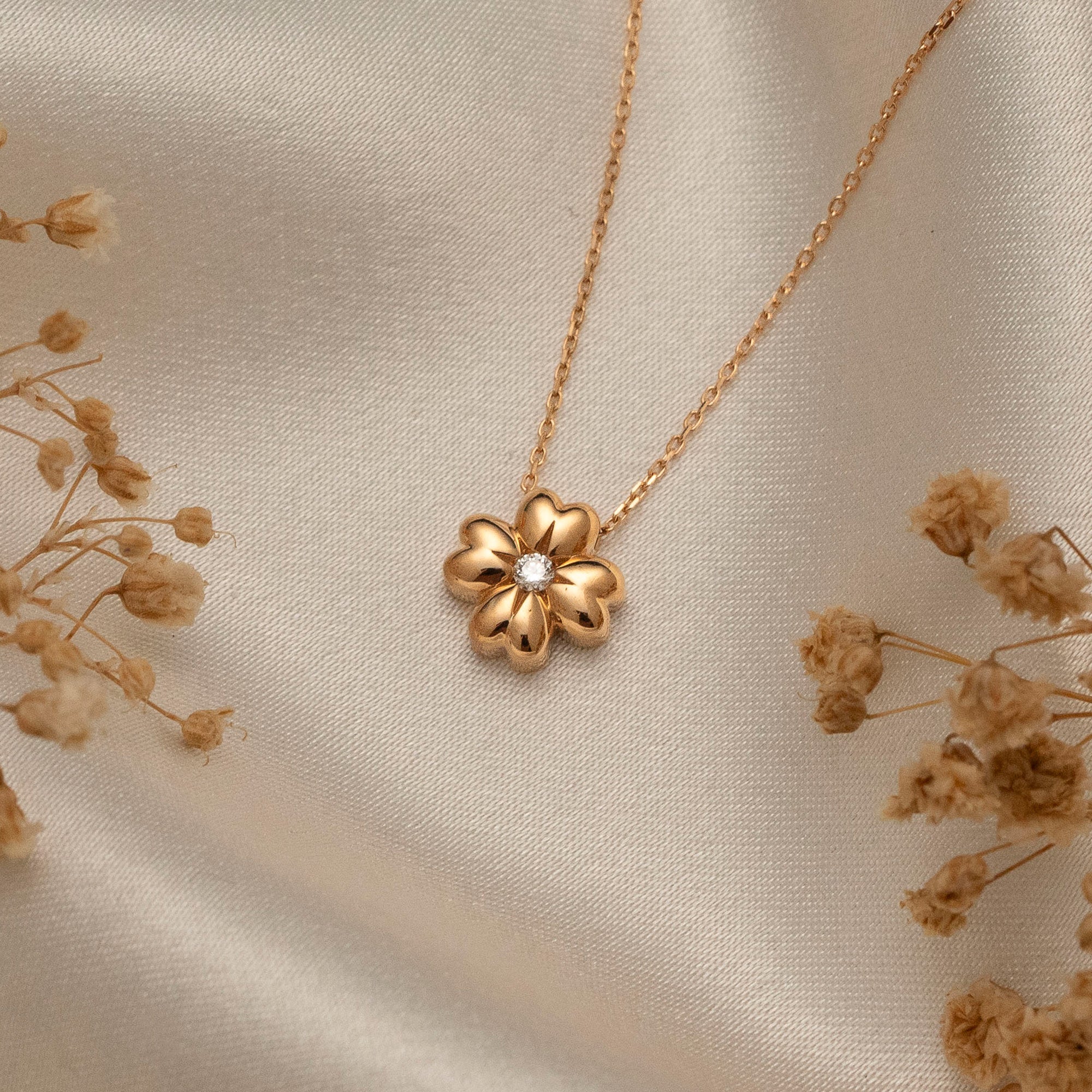 Arel Custom Jewelry 14k solid gold minimalist necklace featuring a four leaf clover pendant with a center diamond on a model.