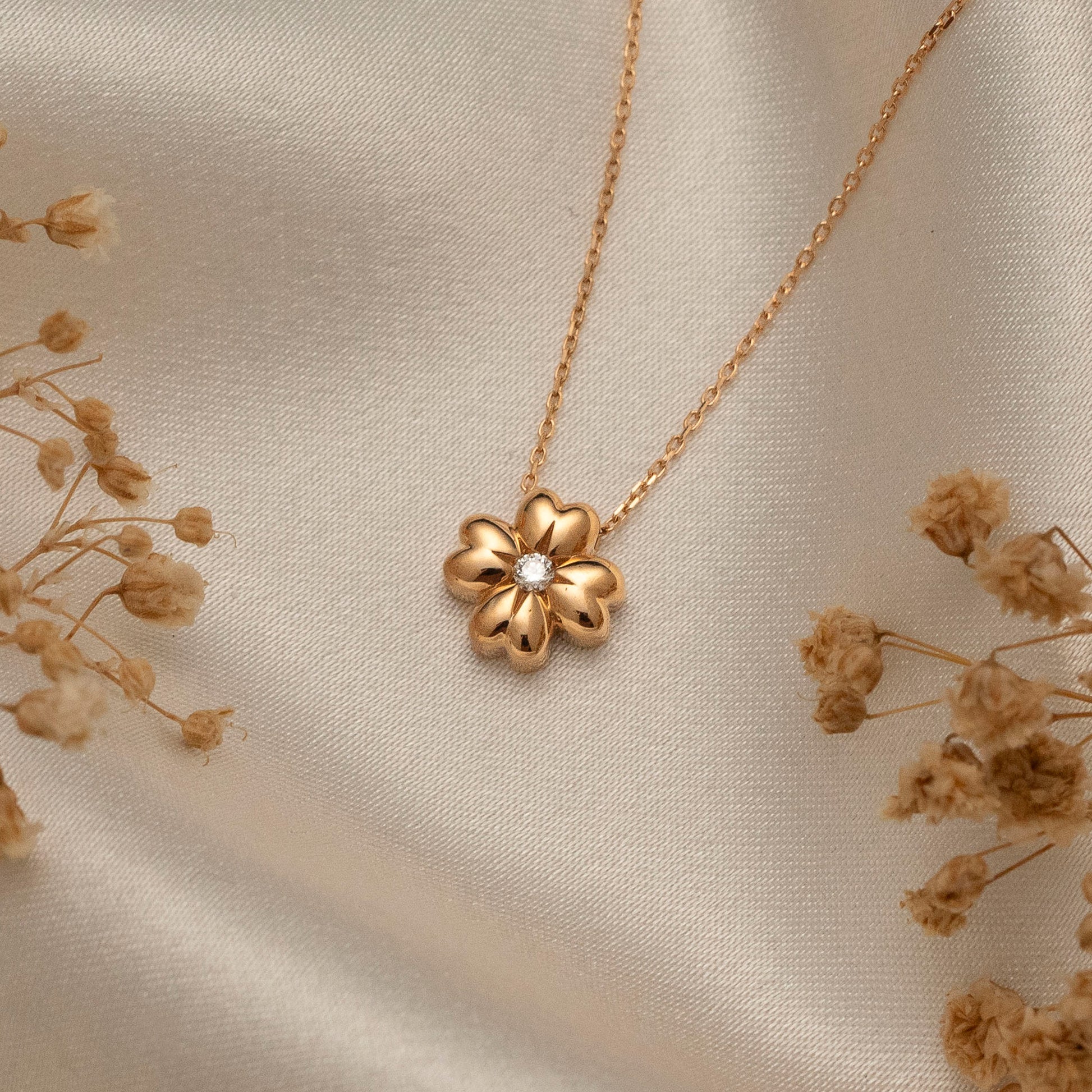 Arel Custom Jewelry 14k solid gold minimalist necklace featuring a four leaf clover pendant with a center diamond on a model.