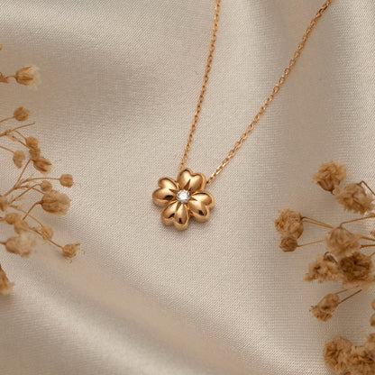 Arel Custom Jewelry 14k solid gold minimalist necklace featuring a four leaf clover pendant with a center diamond on a model.