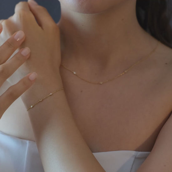 Arel Custom Jewelry 14k solid gold dainty station bracelet featuring three bezel set natural diamonds on a model's wrist