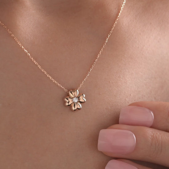 Arel Custom Jewelry 14k solid gold minimalist necklace featuring a four leaf clover pendant with a center diamond on a model.