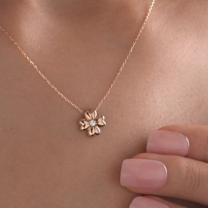 Arel Custom Jewelry 14k solid gold minimalist necklace featuring a four leaf clover pendant with a center diamond on a model.