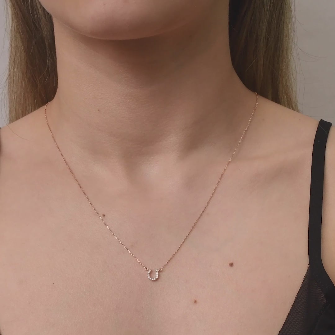 Arel Custom Jewelry 14k solid gold dainty necklace featuring a stationary pave diamond horseshoe pendant on a model.