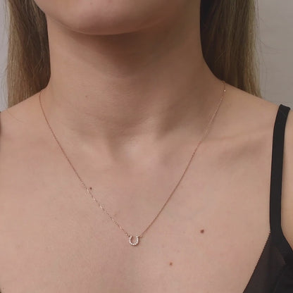 Arel Custom Jewelry 14k solid gold dainty necklace featuring a stationary pave diamond horseshoe pendant on a model.