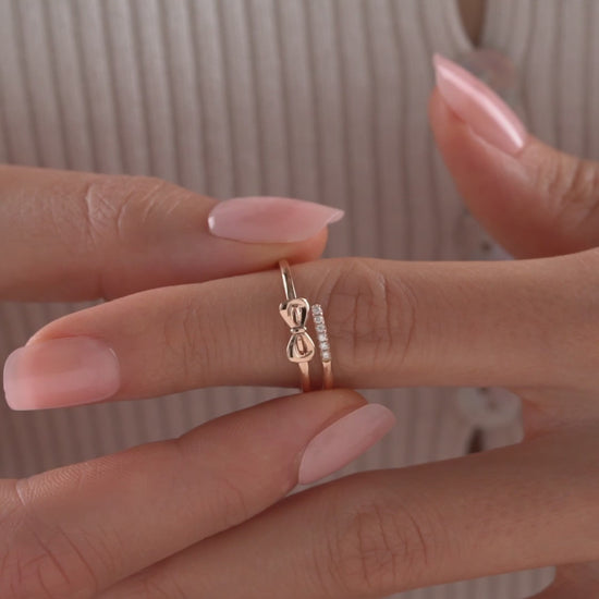 Arel Custom Jewelry 14k solid gold double band wrap ring featuring a polished bow and a pave diamond row on a model's finger.