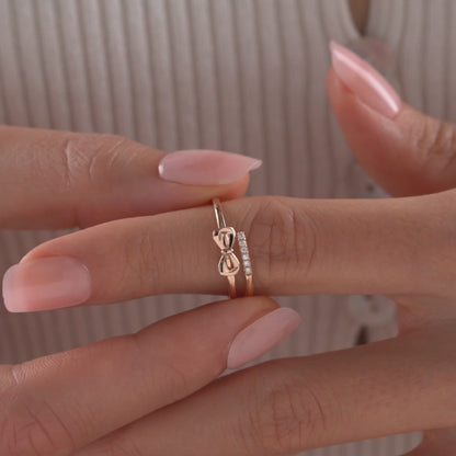 Arel Custom Jewelry 14k solid gold double band wrap ring featuring a polished bow and a pave diamond row on a model's finger.