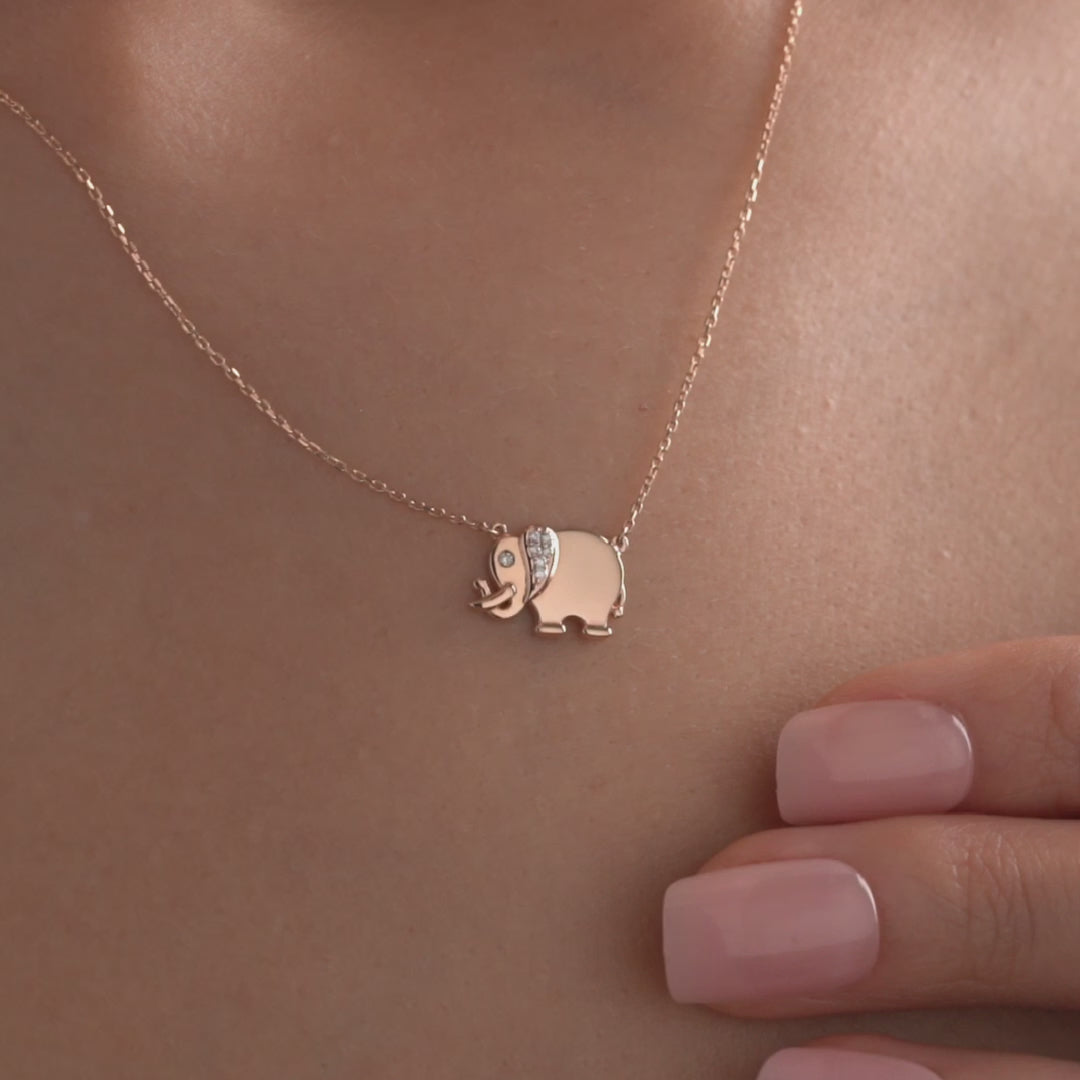 Arel Custom Jewelry 14k solid gold necklace featuring a polished elephant pendant with a pave diamond ear and trunk up on a model.