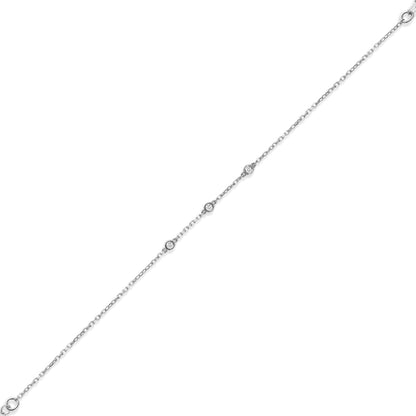 Arel Custom Jewelry 14k solid gold dainty station bracelet featuring three bezel set natural diamonds on a model's wrist